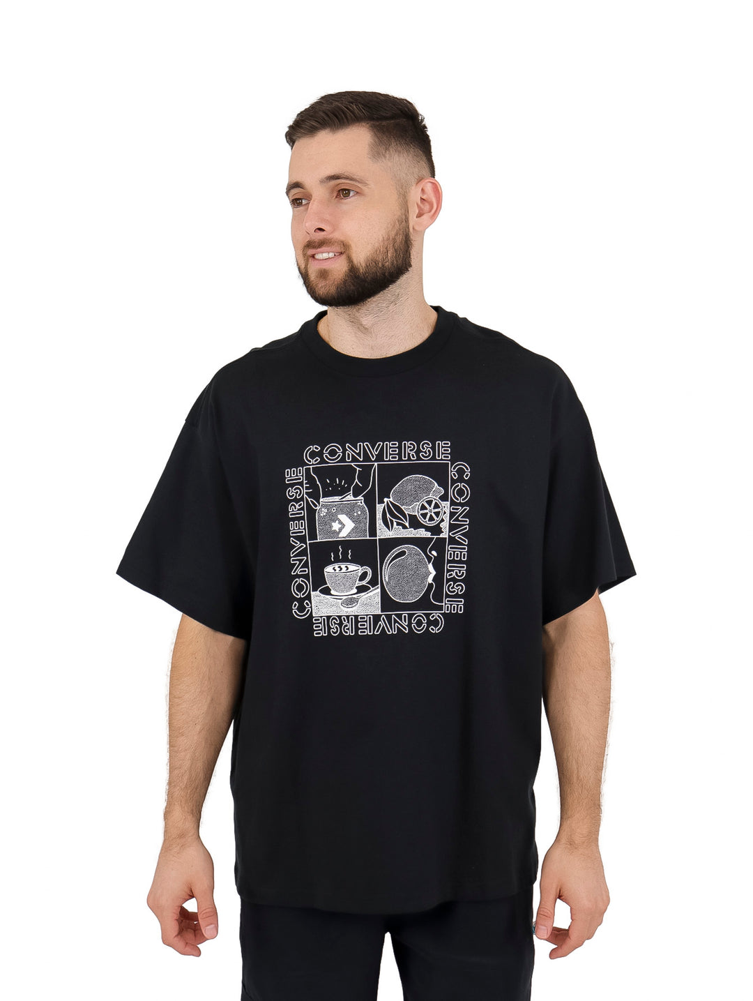 Hombre vistiendo playera negra de manga corta marca Converse con estampado gráfico blanco en el pecho.