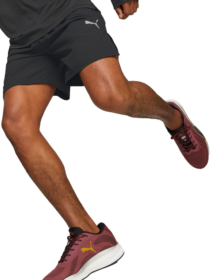Hombre vistiendo shorts deportivos PUMA color negro de corte corto para correr.