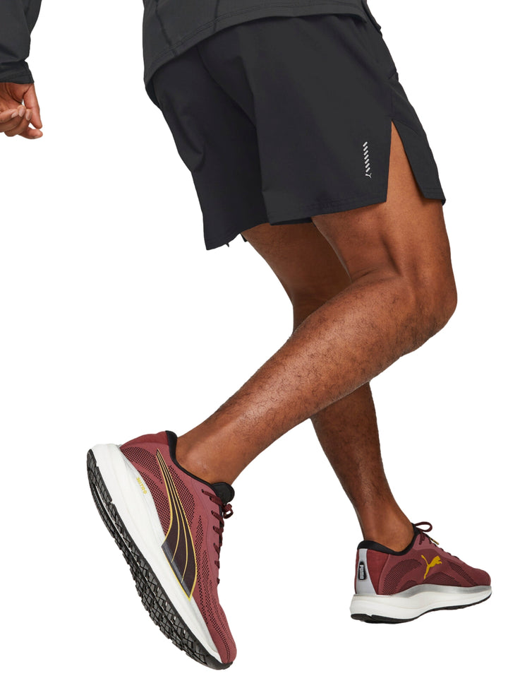 Hombre vistiendo shorts deportivos PUMA color negro de corte corto para correr.