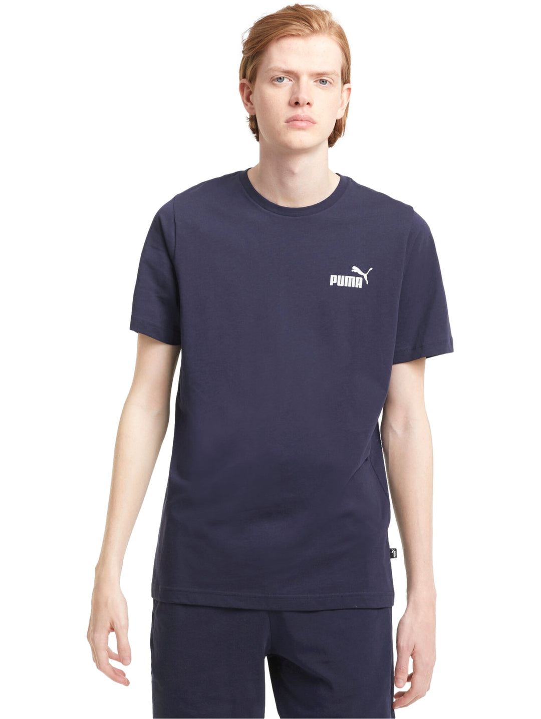 Hombre vistiendo camiseta PUMA de color azul marino con logotipo pequeño en el pecho.