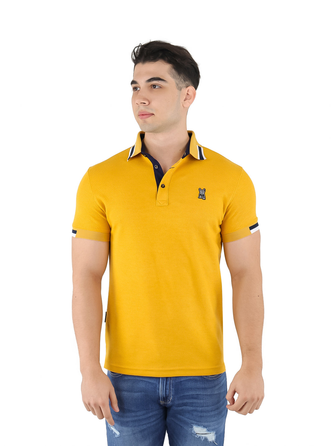 Hombre vistiendo playera polo color mostaza con cuello y detalles en azul marino y blanco.