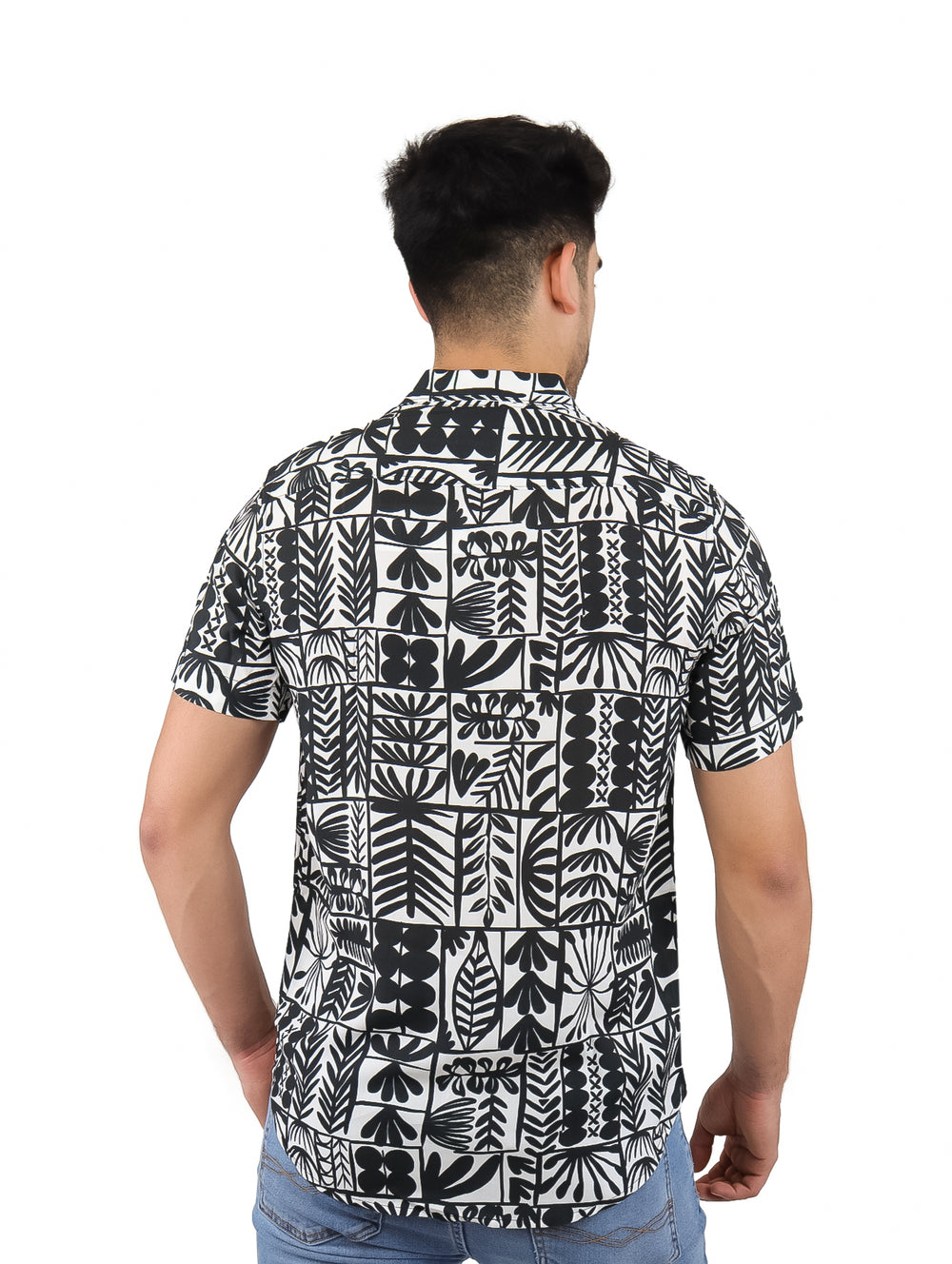 Hombre vistiendo camisa de manga corta con estampado botánico en colores blanco y negro.