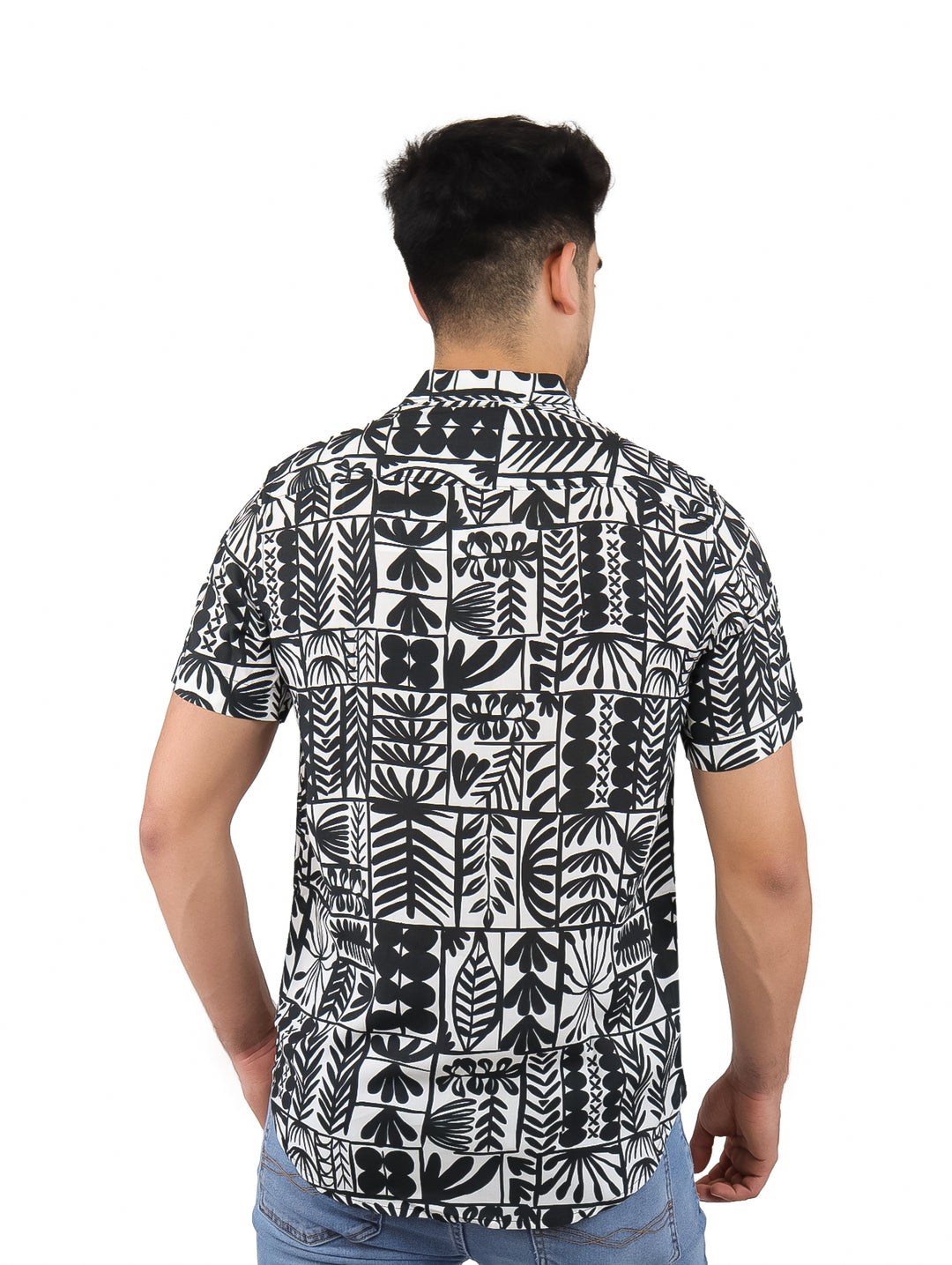 Hombre vistiendo camisa de manga corta con estampado botánico en colores blanco y negro.