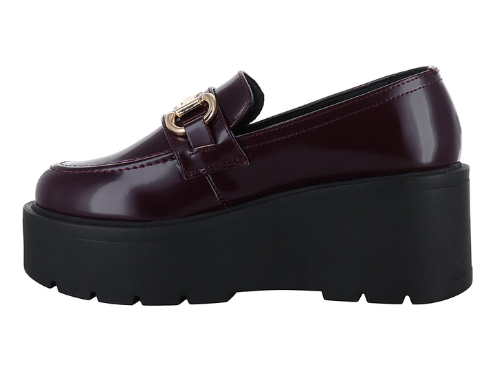 Mocasín color vino brillante con hebilla dorada y suela de plataforma negra gruesa.
