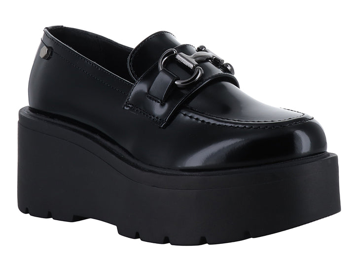 Zapato mocasín negro de alto brillo con plataforma alta y detalle de hebilla metálica.