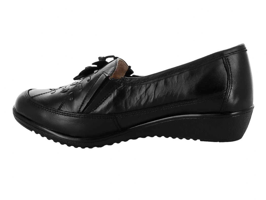 Zapato plano color negro de material napa con detalle decorativo de flor en la parte superior.