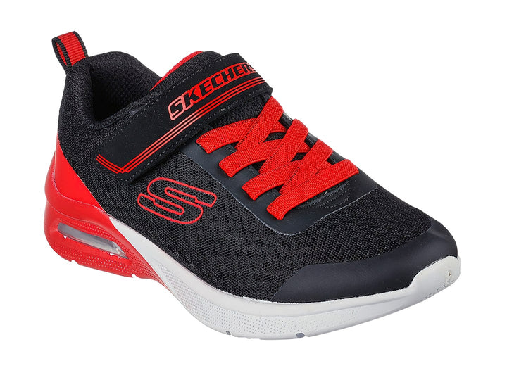 Tenis deportivos Skechers para niño en colores negro y rojo con suela blanca y cierre de velcro.
