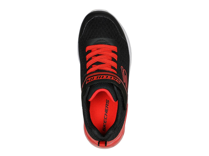 Tenis deportivos Skechers para niño en colores negro y rojo con suela blanca y cierre de velcro.
