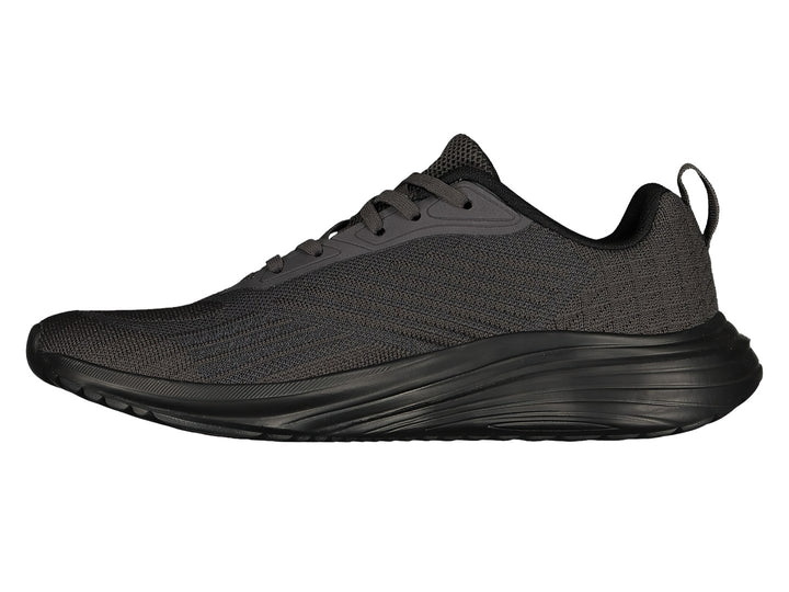 Par de tenis deportivos Charly en color gris oscuro con suela negra y agujetas coordinadas.