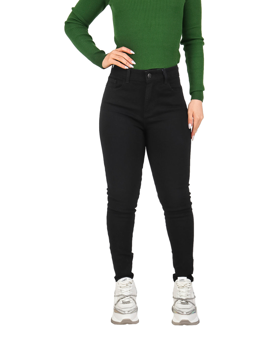 Mujer vistiendo jeans skinny negros de tiro alto, blusa verde y tenis blancos.