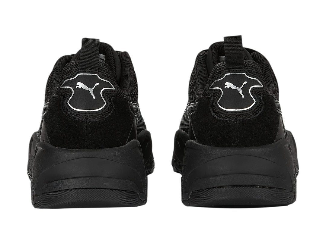 Tenis PUMA Trinity en color negro con detalles plateados y suela robusta.