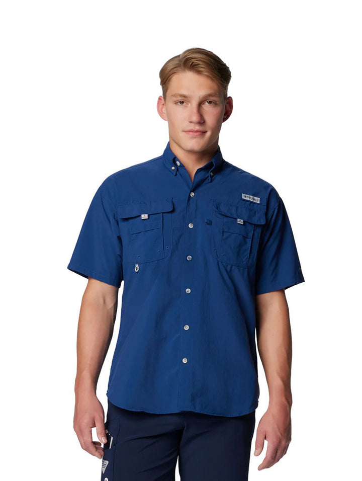 Hombre vistiendo una camisa azul de manga corta marca Columbia con bolsillos frontales.