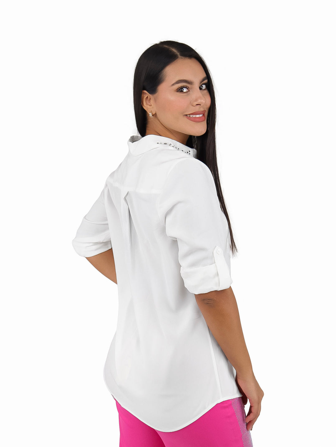 Mujer vistiendo camisa blanca de manga larga con tachuelas en el cuello y texto en el pecho.