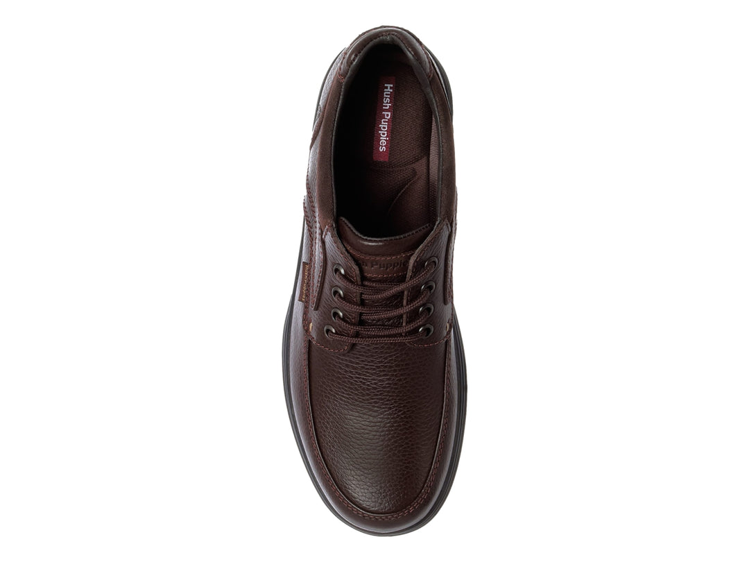 Zapato casual de cuero marrón con cordones y suela negra de la marca Hush Puppies.