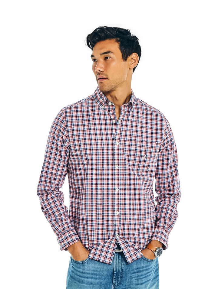 Hombre vistiendo una camisa de cuadros en tonos rojo, blanco y azul.