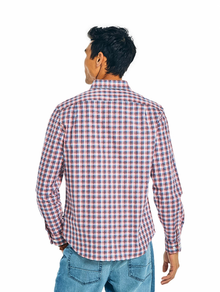 Hombre vistiendo una camisa de cuadros en tonos rojo, blanco y azul.