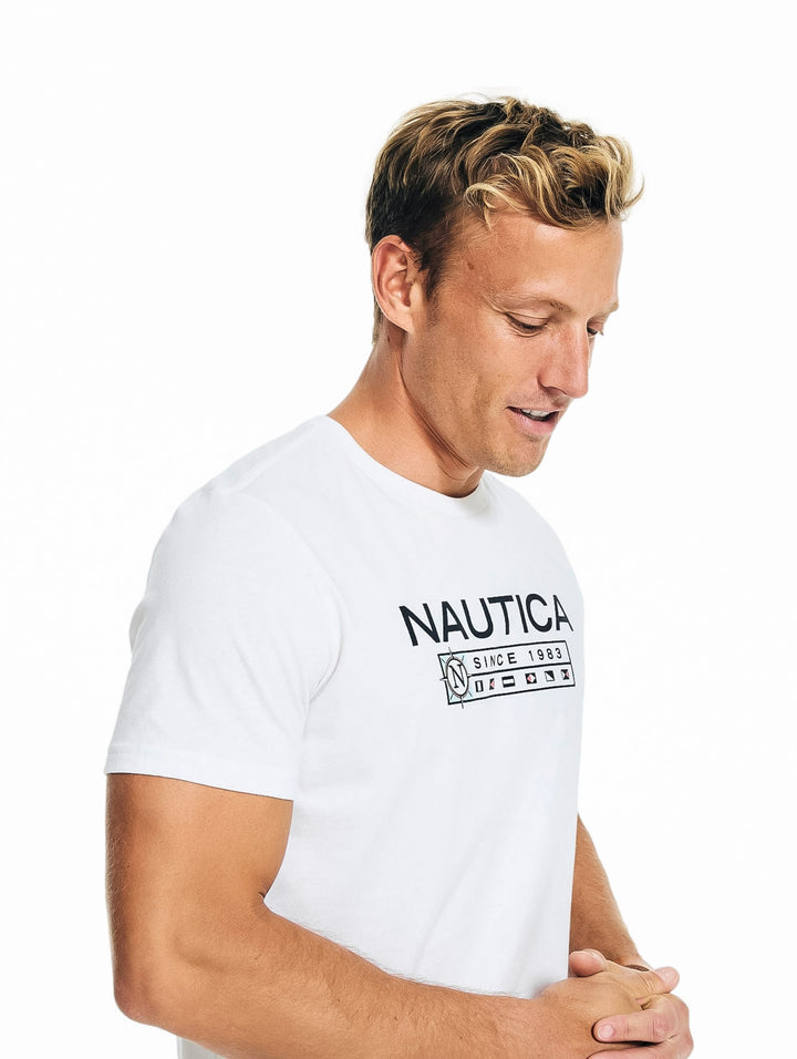 Hombre vistiendo playera blanca de manga corta marca Nautica con logotipo negro en el pecho.