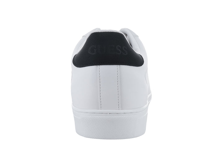 Tenis blancos Guess con detalle negro en el talón y suela blanca.