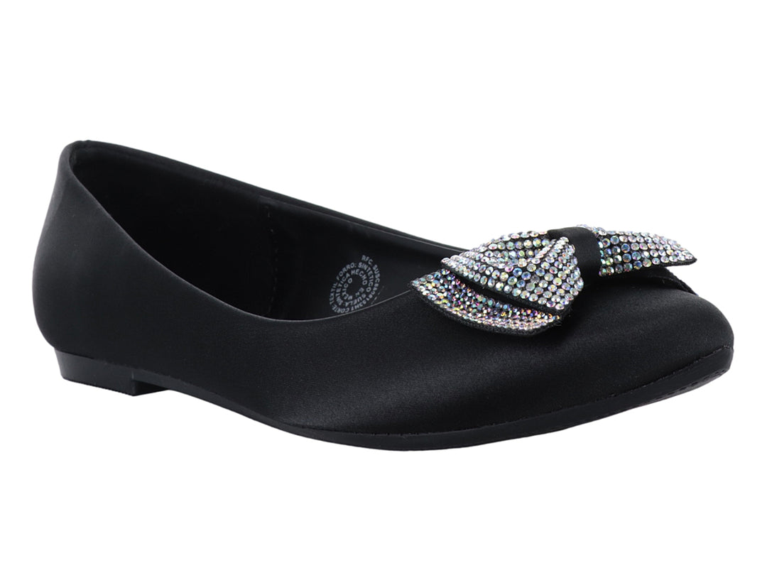 Zapatos planos negros de material brillante con un moño decorado con pedrería multicolor en la punta.