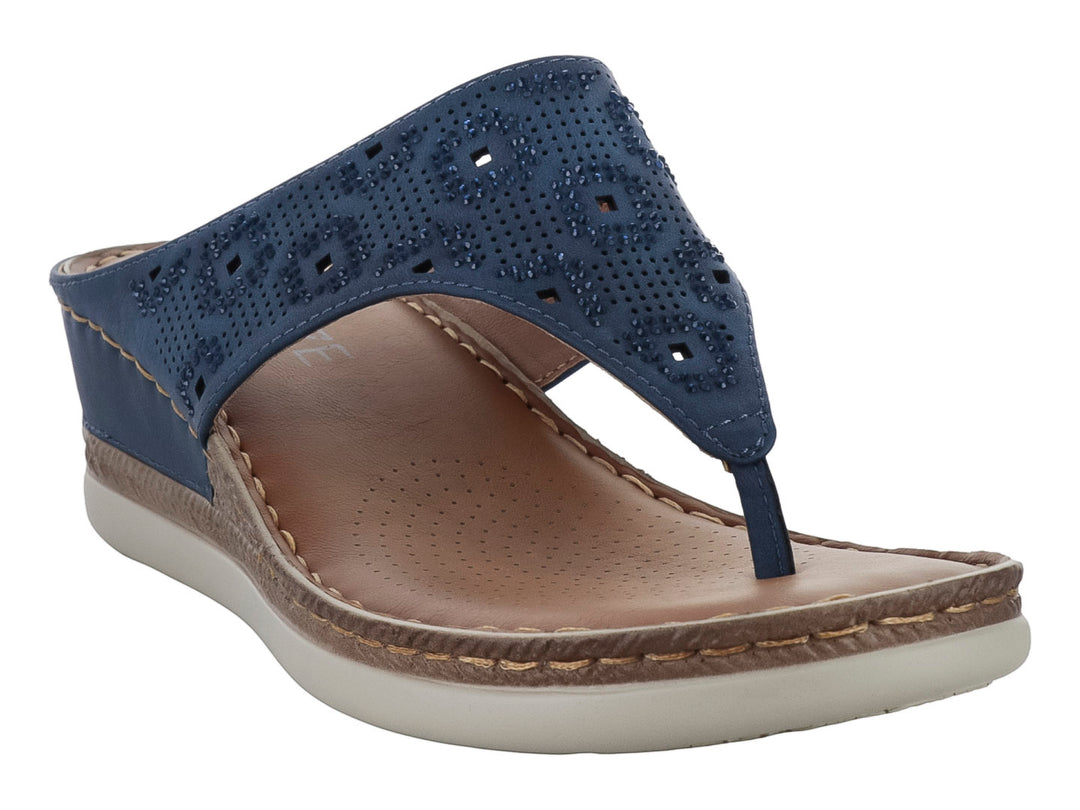 Sandalia azul con correa ancha perforada y suela beige.