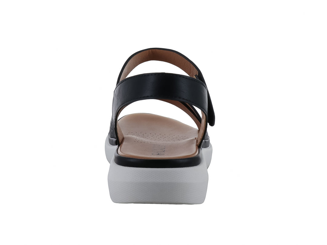 Sandalia casual para mujer color negro con suela blanca de plataforma y correa ajustable al tobillo.
