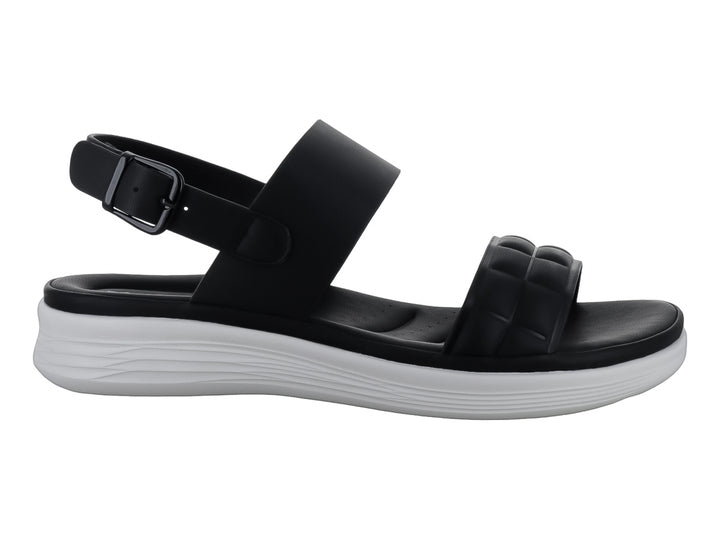 Sandalias negras de plataforma con correas acolchadas y suela blanca para niña.