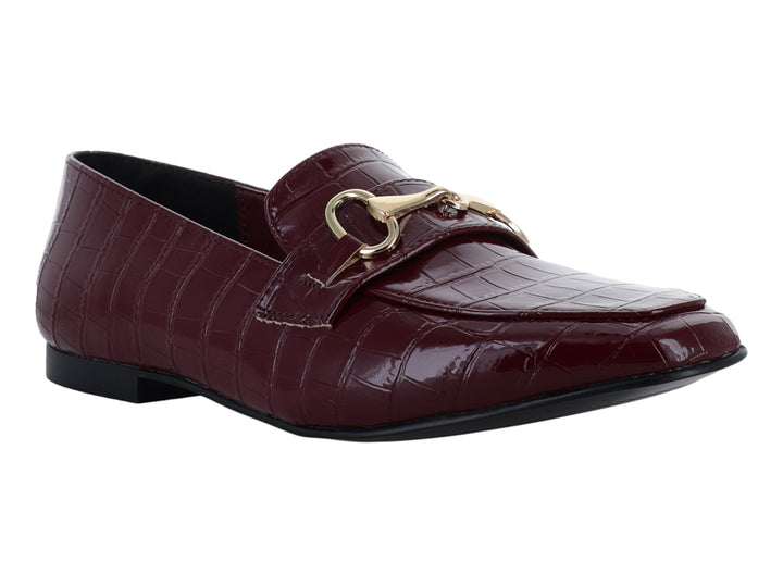 Zapato tipo mocasín color vino en charol con textura de cocodrilo y hebilla dorada decorativa.