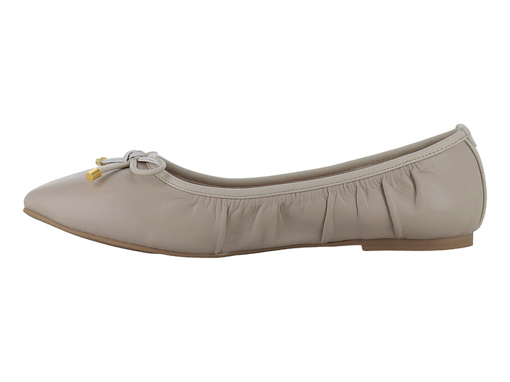 Zapatos planos color beige con moño decorativo y detalles dorados en las puntas.