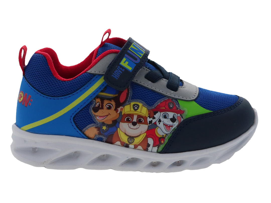 Tenis deportivos azules para niño con personajes de Paw Patrol, suela blanca y cierre de velcro.