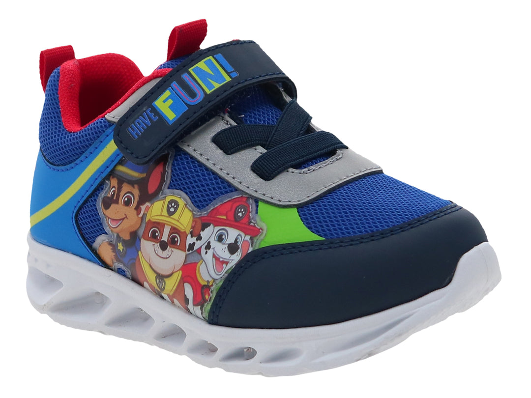 Tenis deportivos azules para niño con personajes de Paw Patrol, suela blanca y cierre de velcro.