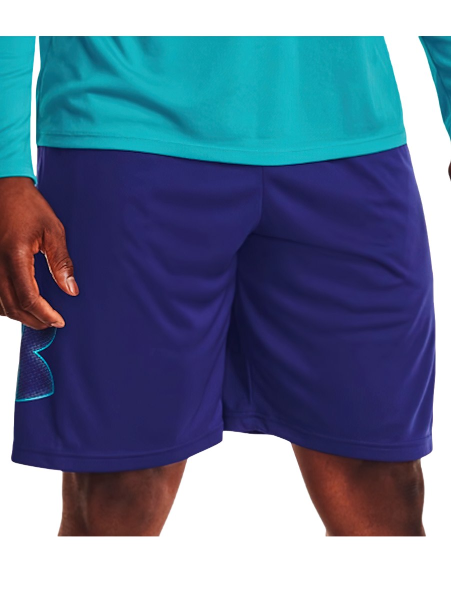 Hombre vistiendo shorts deportivos de color azul marino de la marca Under Armour.
