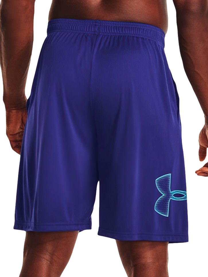 Hombre vistiendo shorts deportivos de color azul marino de la marca Under Armour.
