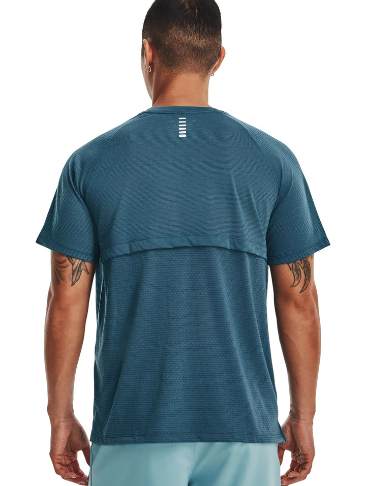 Hombre usando camiseta deportiva Under Armour de color azul con logo blanco en el pecho.