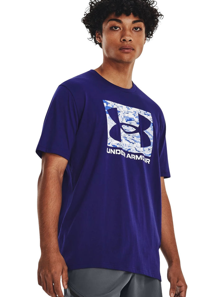 Hombre vistiendo camiseta deportiva azul de manga corta con logotipo de Under Armour en el pecho.