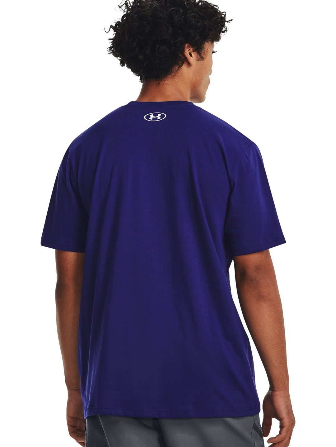 Hombre vistiendo camiseta deportiva azul de manga corta con logotipo de Under Armour en el pecho.