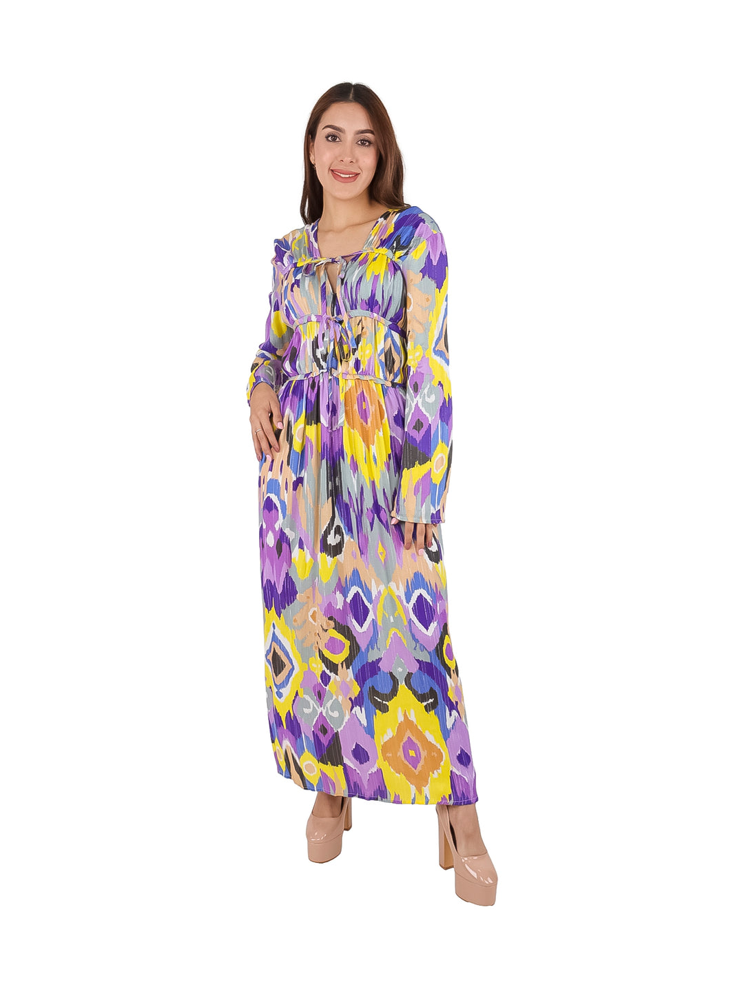 Mujer vistiendo un vestido largo multicolor con patrones geométricos en tonos morado y amarillo.