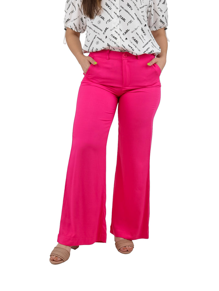 Mujer vistiendo pantalones acampanados de color fucsia vibrante.
