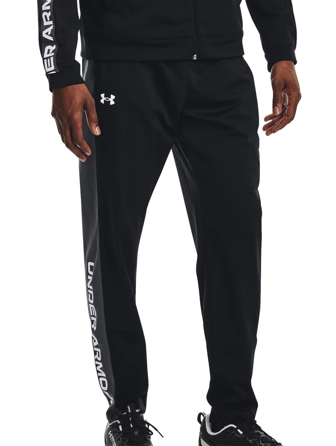 Pantalones deportivos negros Under Armour para entrenamiento con texto blanco en la pierna.