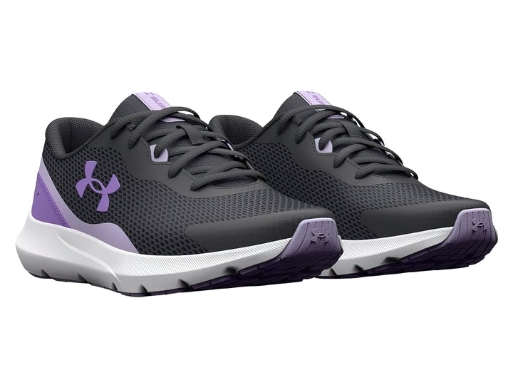Tenis Under Armour Surge 3 en color gris con detalles morados y suela blanca para niña.