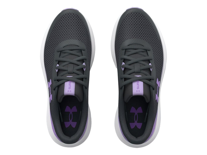 Tenis Under Armour Surge 3 en color gris con detalles morados y suela blanca para niña.