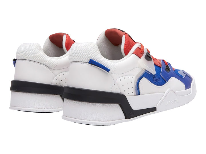 Tenis deportivos Lacoste en colores blanco, azul y rojo con suela blanca y detalles en negro.