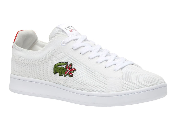 Tenis blancos Lacoste de tela con detalle rojo en el talón y logotipo bordado en el costado.