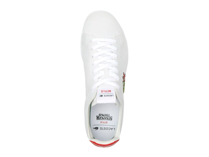 Tenis blancos Lacoste de tela con detalle rojo en el talón y logotipo bordado en el costado.