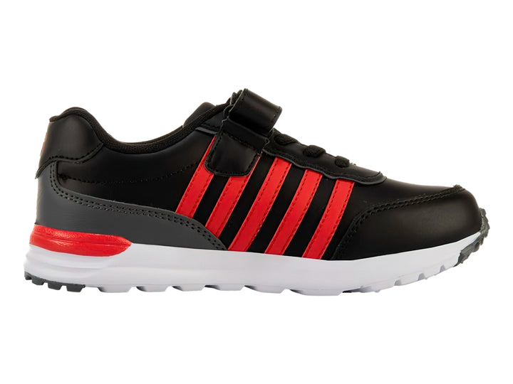 Tenis K-SWISS color negro con franjas rojas laterales, suela blanca y cierre de velcro para niño.
