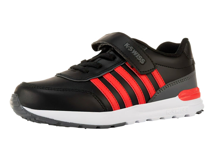 Tenis K-SWISS color negro con franjas rojas laterales, suela blanca y cierre de velcro para niño.
