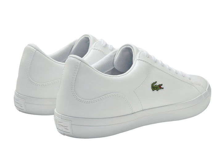 Tenis blancos de cuero marca Lacoste con logotipo de cocodrilo verde en el lateral.