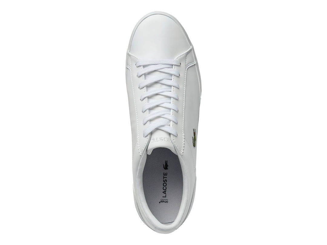 Tenis blancos de cuero marca Lacoste con logotipo de cocodrilo verde en el lateral.