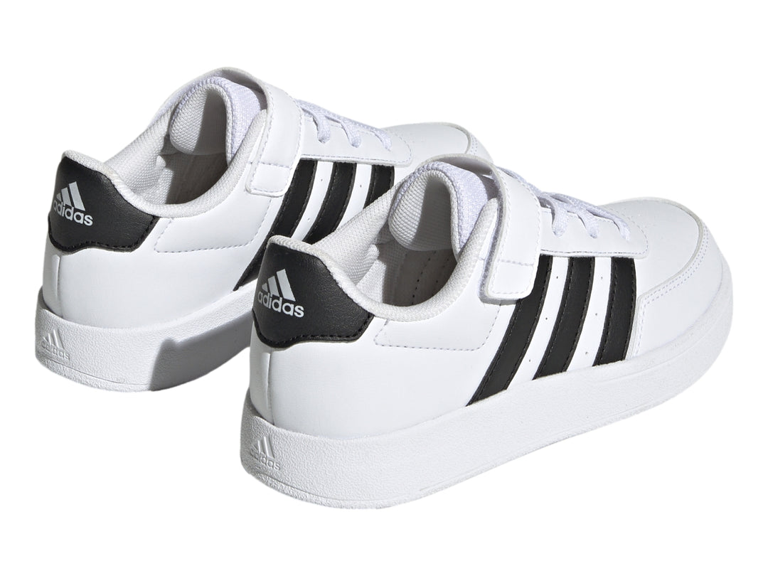 Tenis Adidas Breaknet 2.0 color blanco con tres franjas negras laterales, cierre de velcro y cordones para niño.