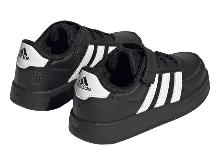 Tenis Adidas Breaknet 2.0 color negro con tres franjas blancas laterales y cierre de banda elástica para niños.
