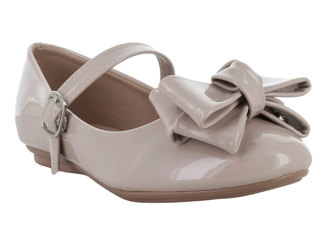Zapato plano para niña en color maquillaje con acabado de charol brillante y un moño decorativo al frente.